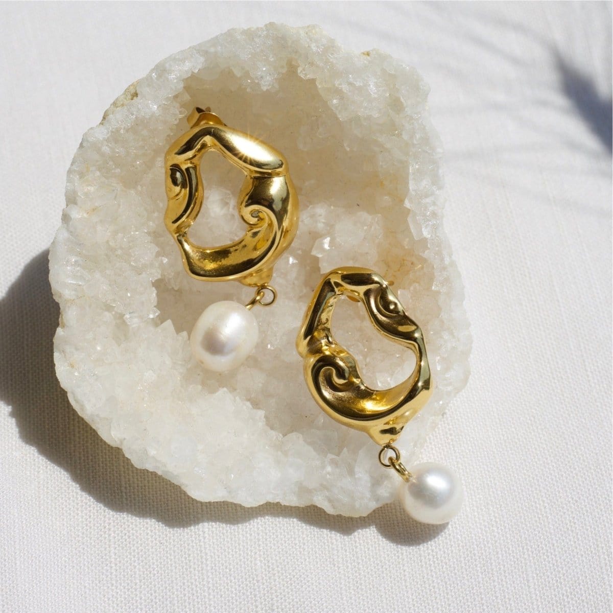 Close-Up of Araceli Gold Hoops with Pearls Displayed on a White Shell